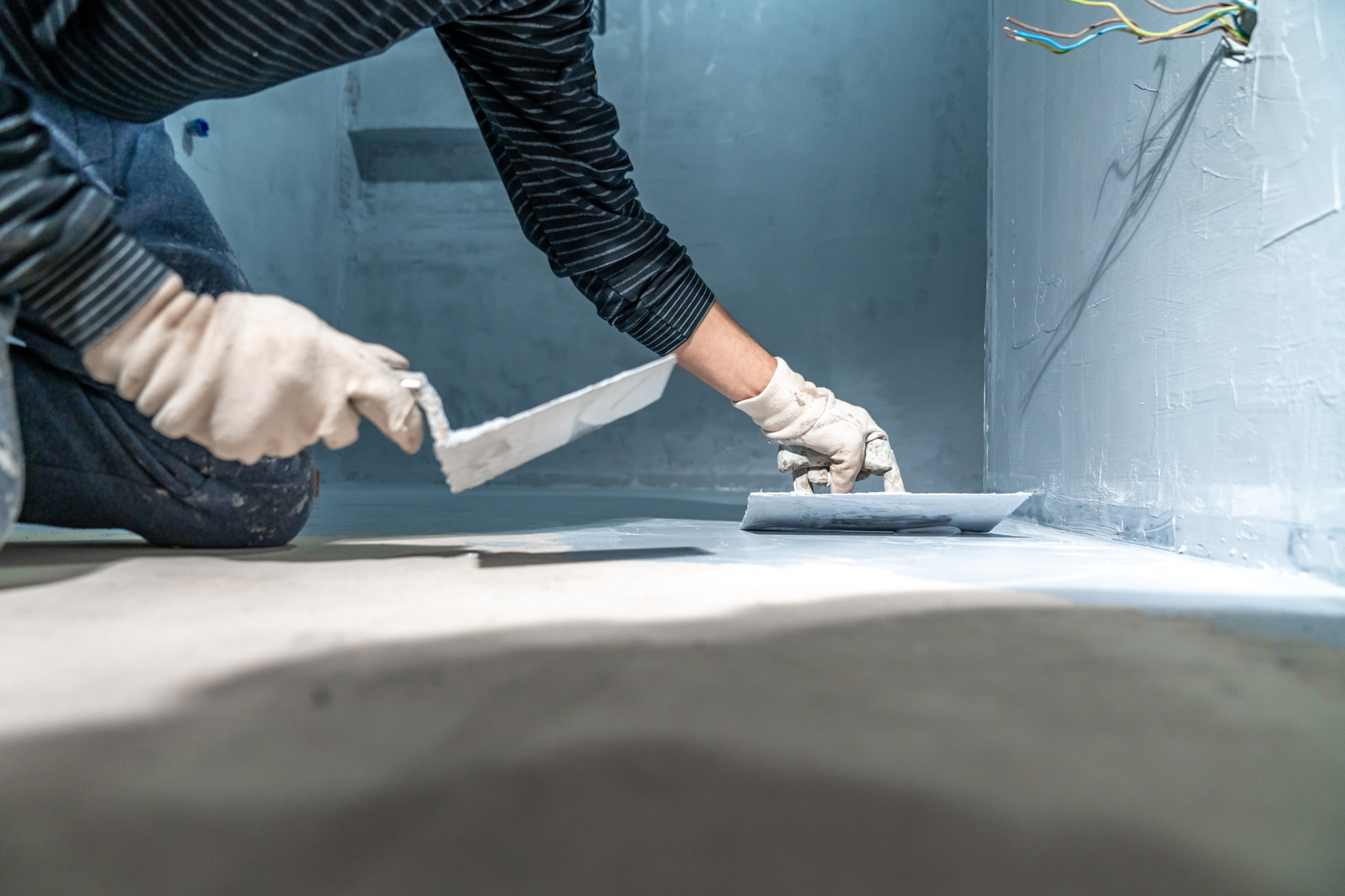 construction modifications of the floor and walls with trowel of a room in a new building
